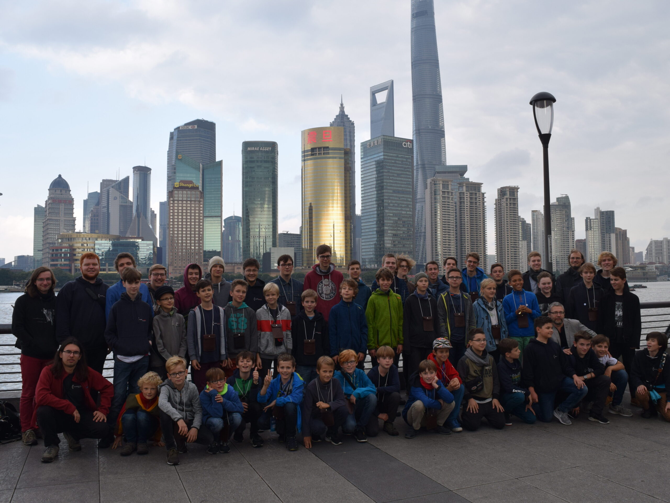 eine große Gruppe von Jungen und jungen Männern vor der Skyline von Shanghai